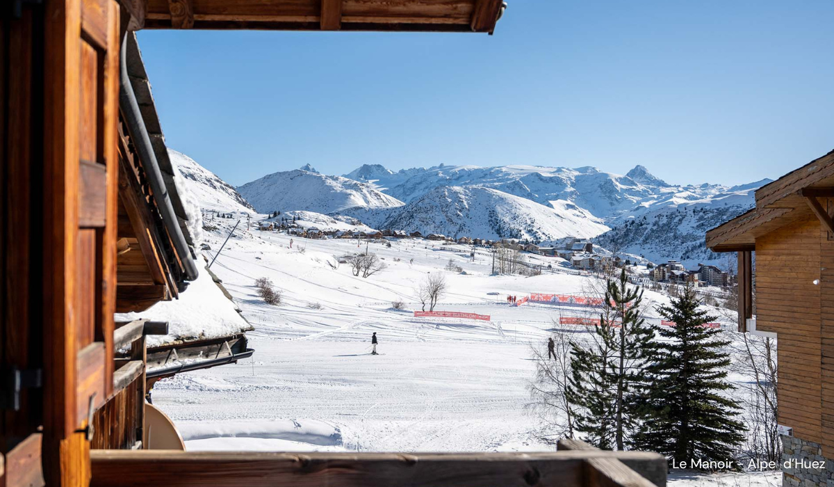 View from Le Manoir balcony, of the piste, someone cruising along it.